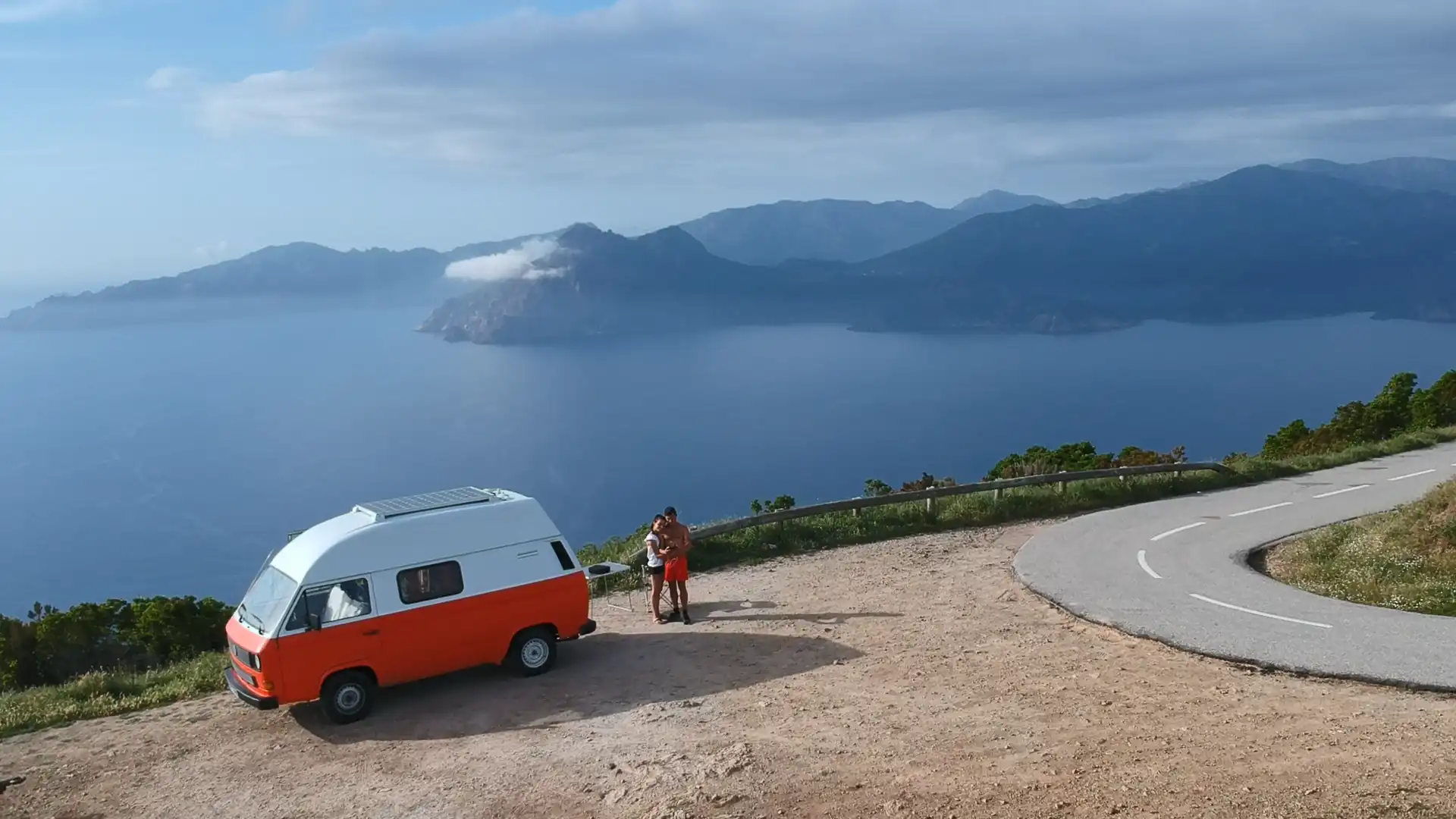 Combi Volkswagen vintage sur une route de montagne en Corse avec vue sur la mer